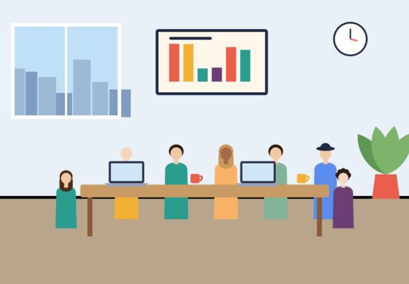 A team seated around a conference table with a chart on the wall