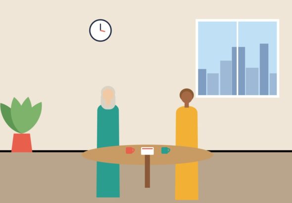 Two colleagues talking over coffee at a small round table