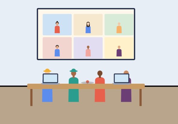 A meeting room with a wall screen showing remote participants