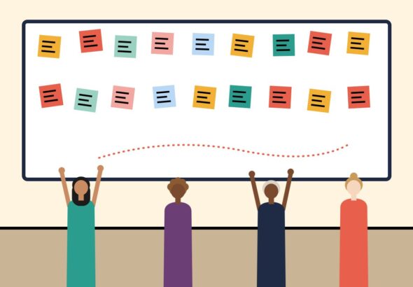A team adding sticky notes to a large whiteboard