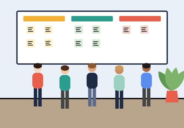 A team standing in front of a task board during a stand-up
