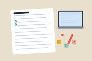 A notebook with a checklist next to a laptop and sticky notes