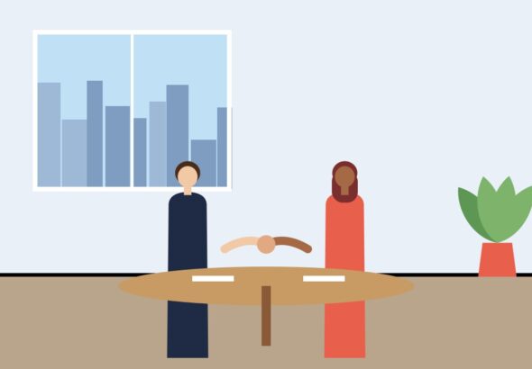 Two professionals shaking hands across a table